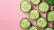 A close up bright green cucumber slices on a pink background, flat lay, top view, copy space.