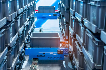 plastic boxes in the cells of the automated warehouse. Metal construction warehouse shelving