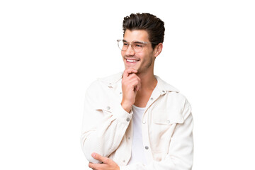 Wall Mural - Young handsome caucasian man over isolated background looking to the side and smiling