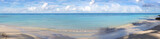 Fototapeta Dmuchawce - Tropical panorama beach with white clouds and blue caribbean sea.