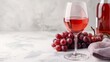 © Jevjenijs - A glass of red wine, a bottle, and a cluster of grapes on a pristine white tablecloth