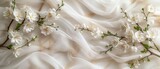 A classic pearl white marble surface adorned with white jasmine flowers and sheer white silk. 