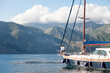 Traveling on yacht at sea. Travelers sailing, enjoying summer vacation. Couple have fun and adventure. Tourists on wooden sailboat. Gorgeous landscape with beautiful nature, mountains, coast