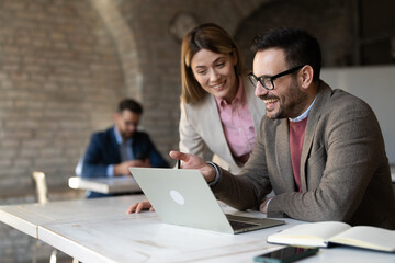 Business woman and businessman working together at office desk