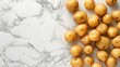 Potatoes lie on the white marble countertop