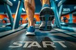 A man is running on a treadmill with the word start on the floor