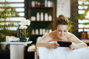 Wall Mural - smiling modern woman in massage cabinet laying on massage table