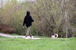 Girl walking a dog in city park. Lady with pet in spring