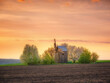 orange color of sky in sunset time above field with old wooden mill
