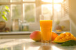 Glass of fresh mango juice on table in kitchen. Space for text