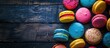 Colorful cookies in a macaroon style over a dark wooden surface.