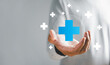 © sorapop - A hand grasps plus icon for medical care, signifying advantages. Health insurance health concept featuring access to welfare health and unoccupied space.