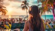 © GulArt - Rear view of a young woman dj with headphones mixing music in beach party on the seaside