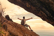 Happy explorer hiker traveler in mountains feeling grateful with open arms up to the ocean sunrise living a healthy life