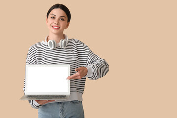 Female programmer with laptop on beige background