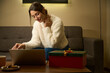 Woman watching laptop on couch at table during Christmas or New Year