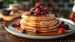 A stack of pancakes with fresh berries and maple syrup drizzling down the sides
