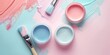 Top view of open paint cans with vibrant pink, blue, and yellow paints and corresponding brush strokes on a pastel background, depicting a DIY project..