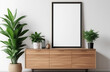 Blank poster frame mockup on white wall living room with wooden sideboard and green plant