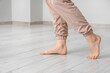 © Pixel-Shot - Barefoot woman walking on laminate floor in light room, closeup