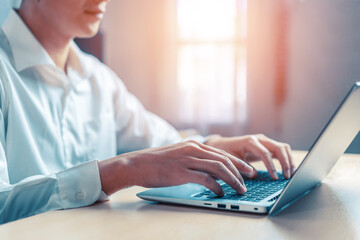 Wall Mural - businessman hand typing on computer keyboard of a laptop computer in office. business and finance co