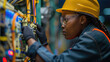 © GulArt - African female technician engineer with helmet and protection eyeglasses checking machine in a factory