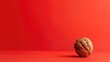 Single walnut on red background with ample copy space