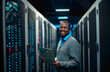 © Danny - IT professional in data center. A cheerful IT engineer stands in the aisle of a data center, holding a tablet and radiating confidence amid the hum of servers.