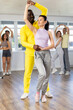 Man and girl are standing next to each other and dancing in pair of salsa. Students practice repeating movements of pair dance