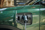 Fototapeta  - Plug inserted in electric car charge port