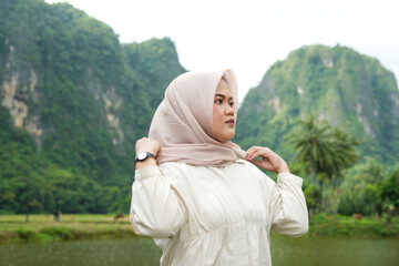 Wall Mural - Portrait of an Asian female model wearing a hijab at a tourist attraction posing