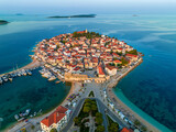 Fototapeta Big Ben - Primosten, Croatia - Aerial view of old town of Primosten peninsula, St. George's Church on a sunny summer morning in Dalmatia, Croatia. Blue and mooring yachts at sunrise on the Adriatic sea coast