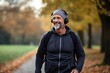 A walk in the fresh air with your favorite music in headphones, away from the noise of the big city. Caucasian middle-aged man during a walk in the autumn park.
