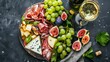 Antipasto plate with prosciutto, cheese, figs and grapes. Appetizer board and white wine. Top view flat lay 