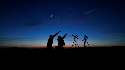 Wall Mural - amateur astronomers looking at the evening skies, observing planets, stars, moon and other celestial