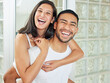 © peopleimages.com - Couple, portrait and piggyback with bathroom, smile and love for relationship bonding. Man, woman and laugh with happiness, romance and morning routine for home oral hygiene with hug and teeth health