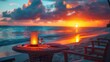A table with a candle and wine glasses on a beach at sunset