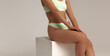 Tanned woman, perfect body shape. Fitness, weight loss and body care . Sexy young woman with in light green lingerie touching chest and isolated on grey, self-acceptance and body positive concept