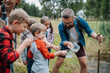© Halfpoint - Teacher showing lake water to school children, during field teaching class. Outdoor active education helping young student to learn about ecosystem.