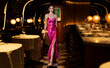 © Westend61 - Beautiful woman in glamorous gown walking at illuminated club