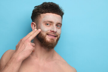 Poster - Handsome man with facial mask on his face against light blue background, space for text