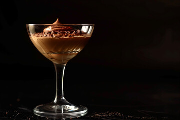 Chocolate mousse in a glass, isolated on a black background