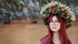 Beautiful red-haired girl in a wreath made of viburnum berries, ears of wheat, flowers and leaves