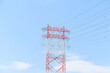 青い空と白と赤で塗られた高圧電線鉄塔