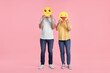 © New Africa - People covering faces with emoticons on pink background
