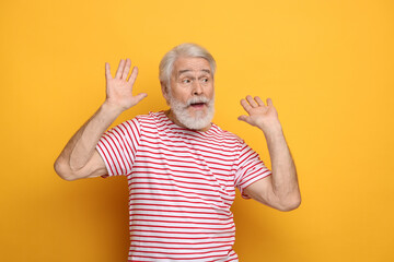 Wall Mural - Senior man with mustache on orange background