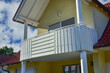 Balkon mit Metall-Geländer und lackierten Holzplanken an einem Wohnhaus