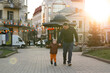 A happy three year old son walks hand in hand with his dad in the city on a sunny spring day. Family fun time and leisure. Spending time