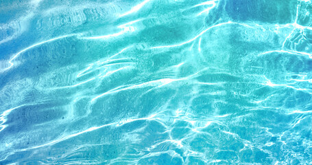 Beautiful turquoise blue ocean water surface with light reflections and highlights. Texture of water close-up macro.