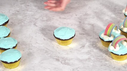 Sticker - Decorating chocolate cupcakes with buttercream frosting and rainbow candy.